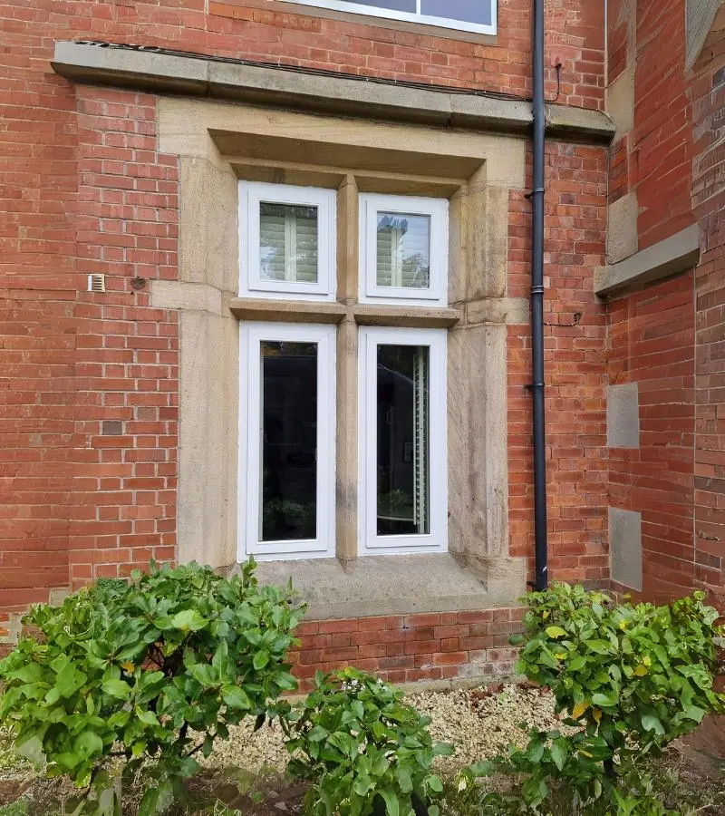 Red brick property with a white timber casement bay window