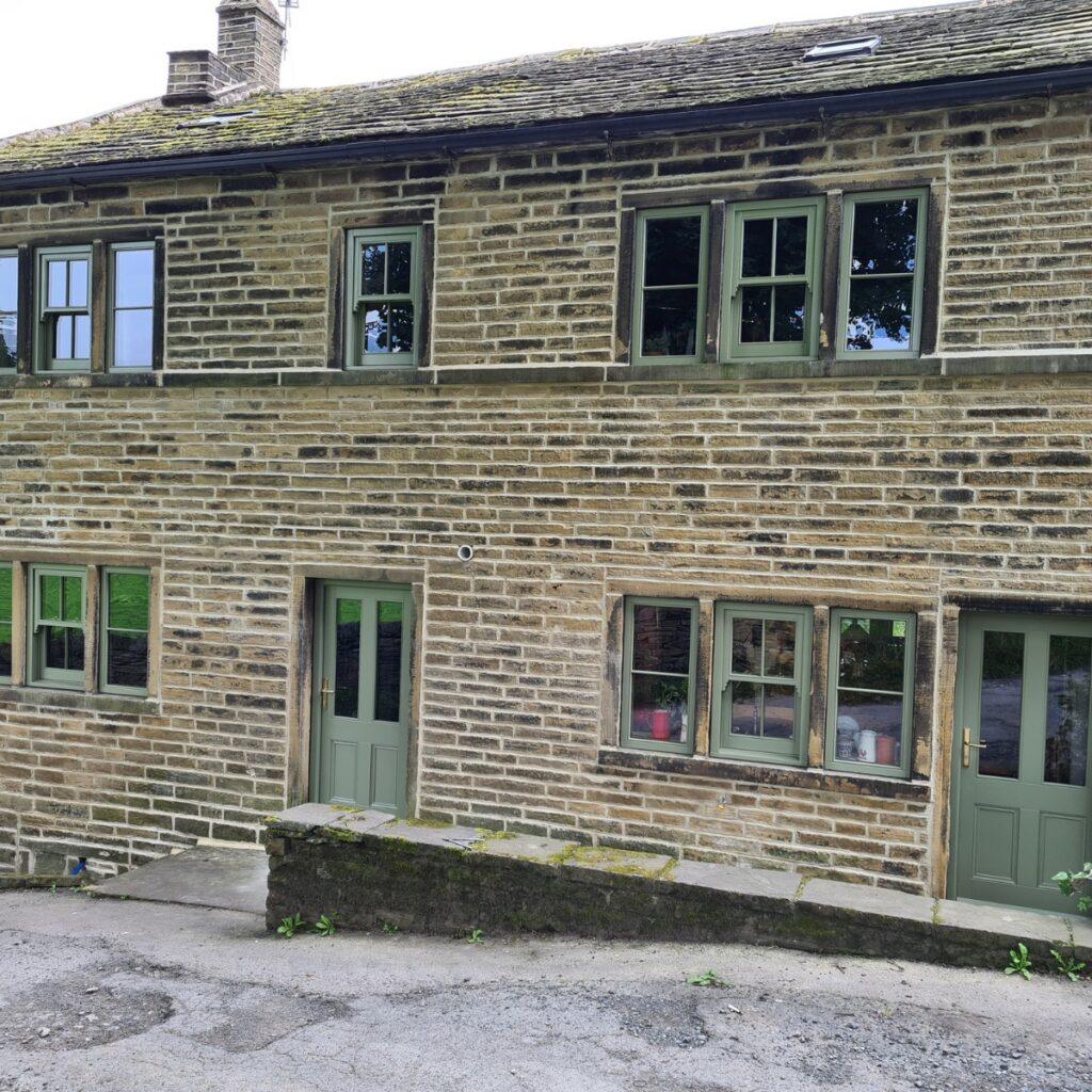 Timber casement window detail on ivy-covered Yorkshire stone cottage, Farrar Joinery