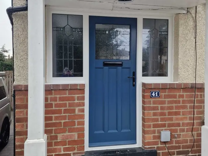 Blue painted timber front door with leaded glass sidelights on a brick residential property